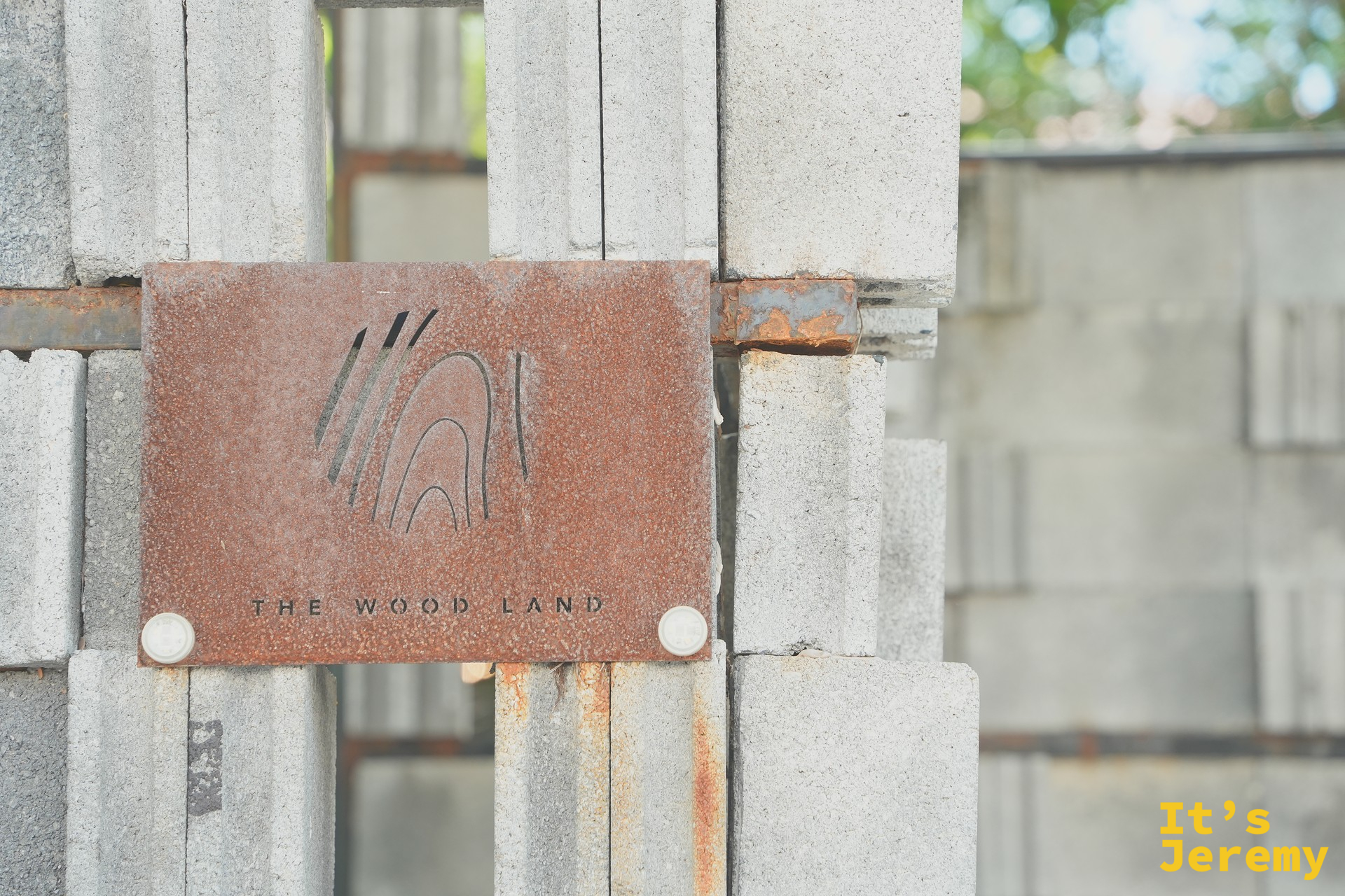 The Wood Land 入口的深色木門與招牌