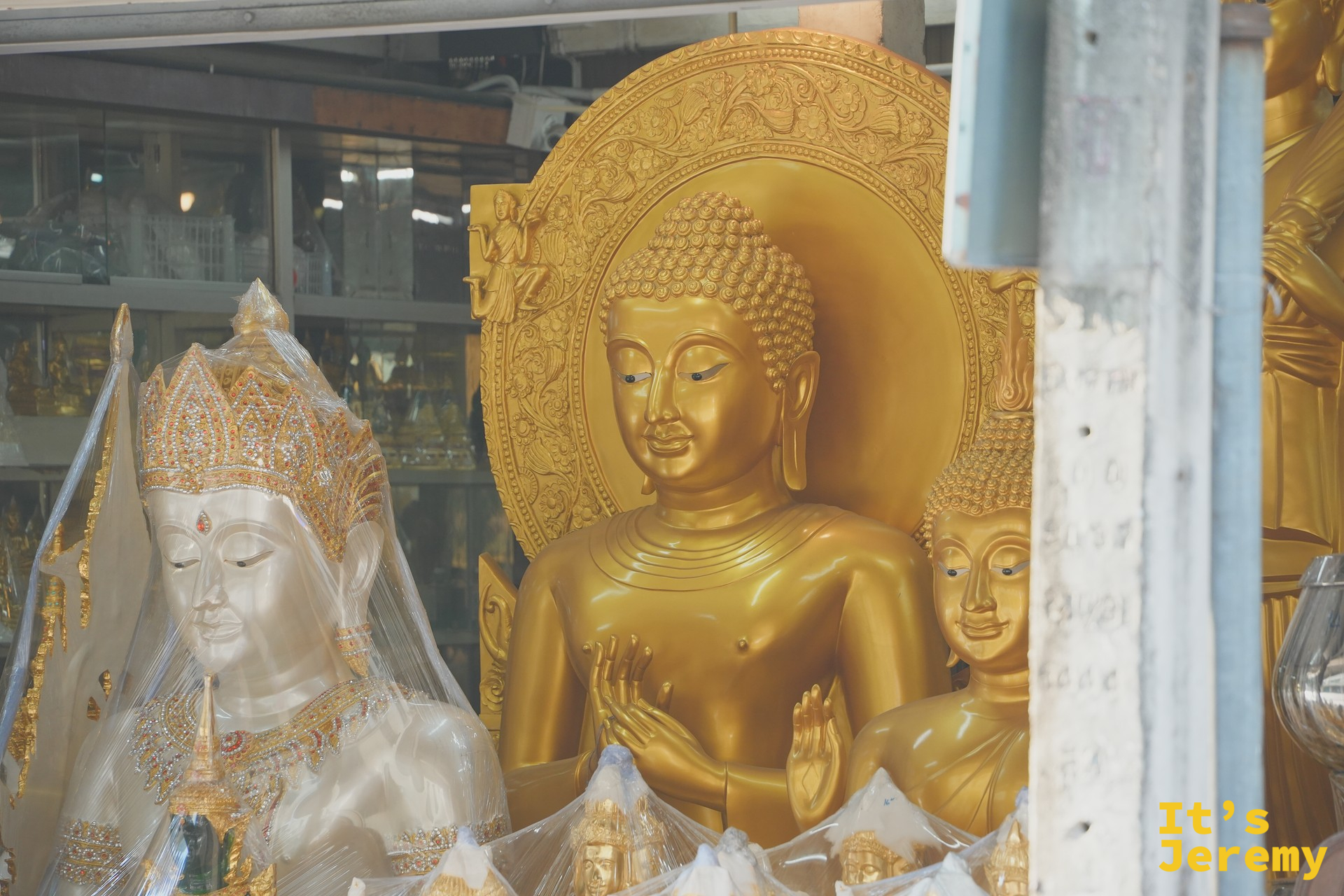 一尊金色坐佛特寫、背後是金色佛光圓盤——泰國寺廟的標準造像