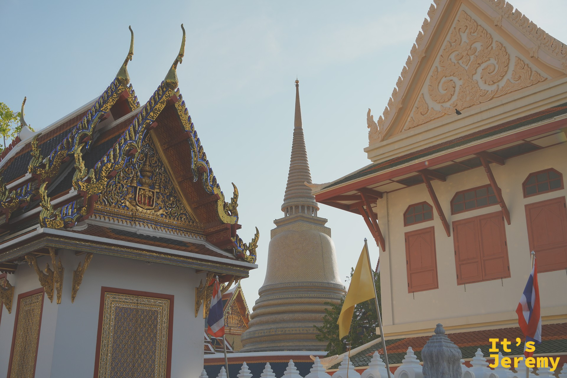 Wat Pho 的金色屋頂與白色佛塔尖端在兩棟建築之間冒出來，這天用「路過視角」帶過去