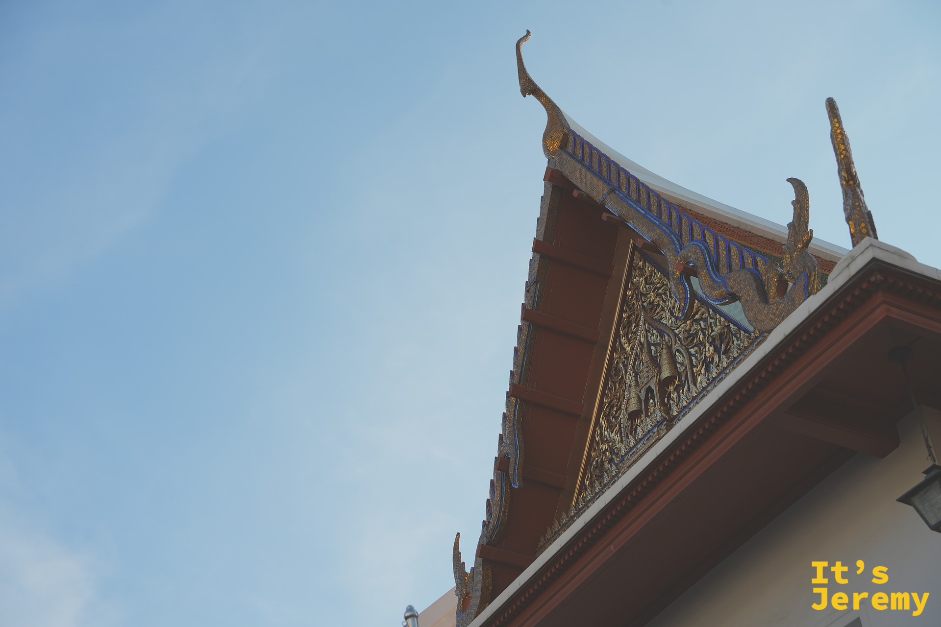 Wat Pho 的山牆與金色屋頂、藍天背景中刺出的山牆雕花特寫