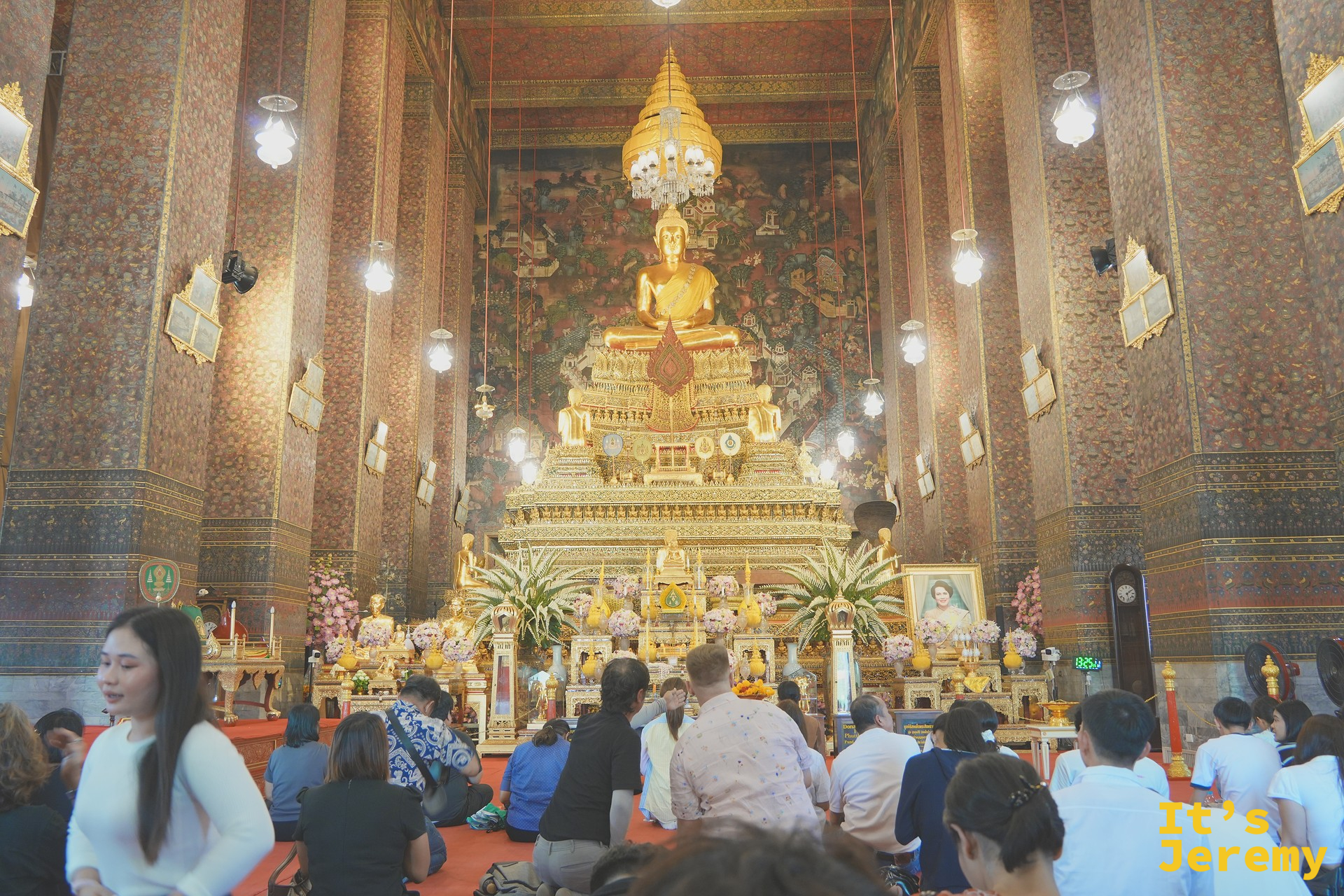 主殿內部全景,金色坐佛 Phra Buddha Deva Patimakorn 高坐台座,信徒跪地禮佛