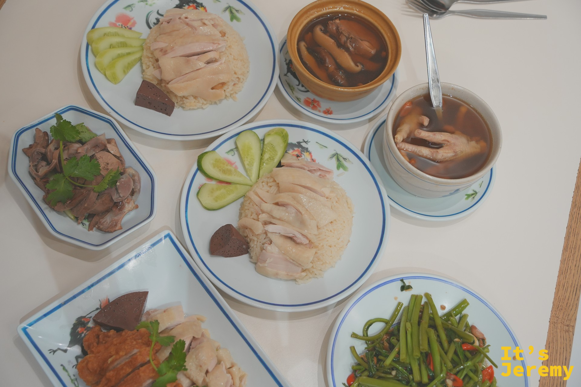 紅大哥兩盤海南雞飯上桌俯拍，配湯品、雞雜與空心菜