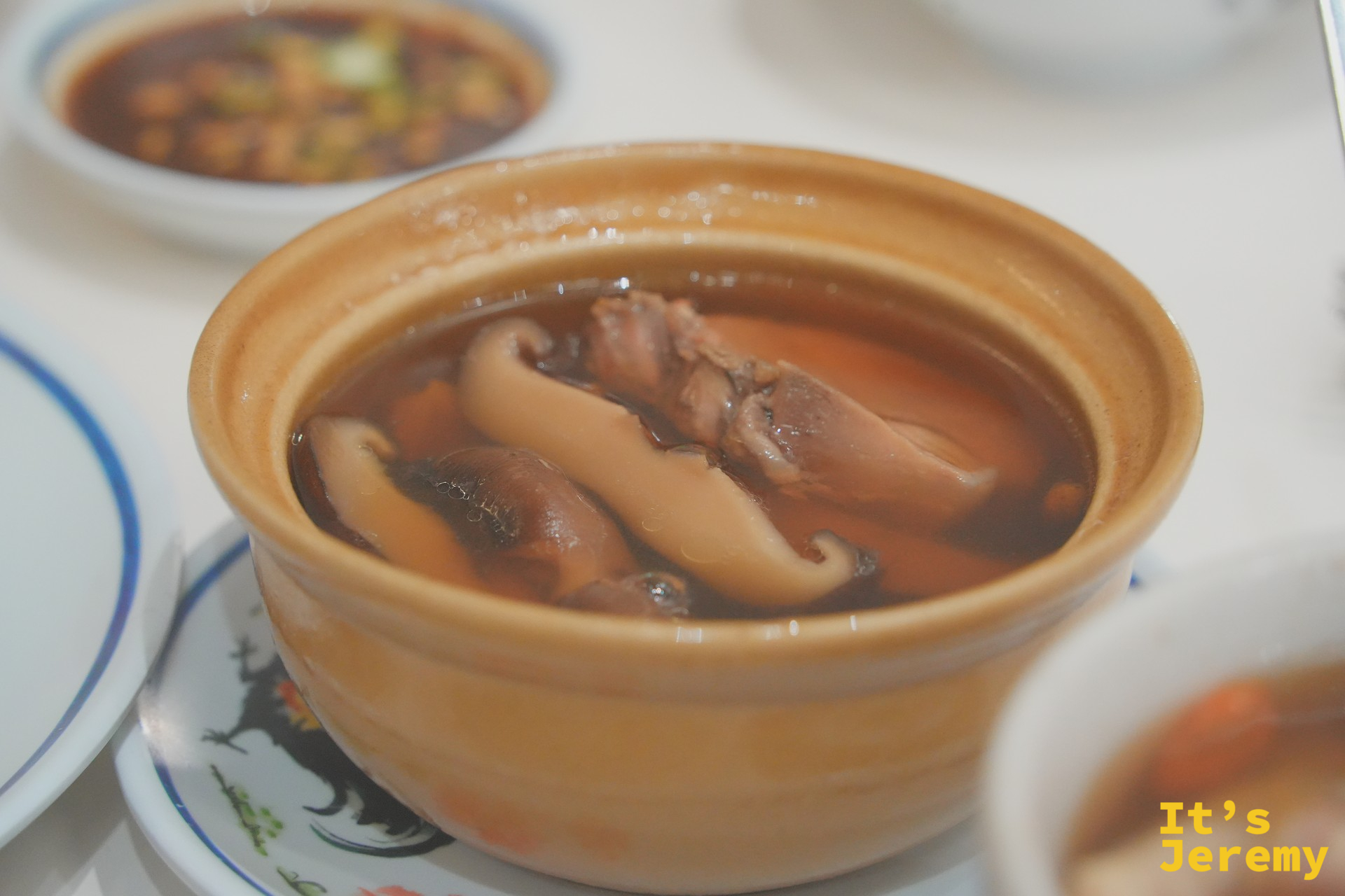 紅大哥香菇燉雞湯特寫：黃色小砂鍋裡的肥厚香菇與雞肉、湯色琥珀