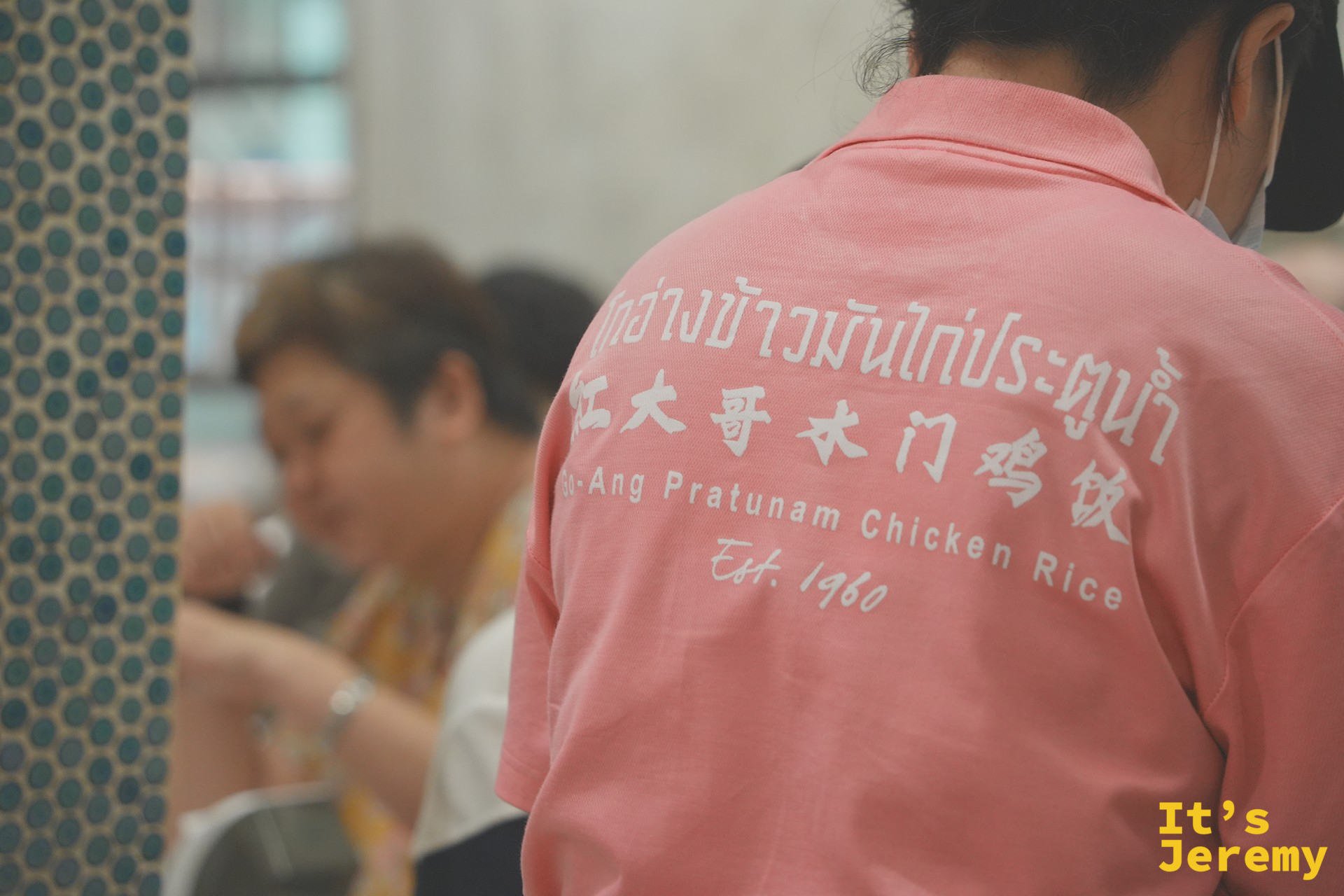 紅大哥粉紅制服員工背面：泰中英三語店名與 Est. 1960 字樣清晰可見