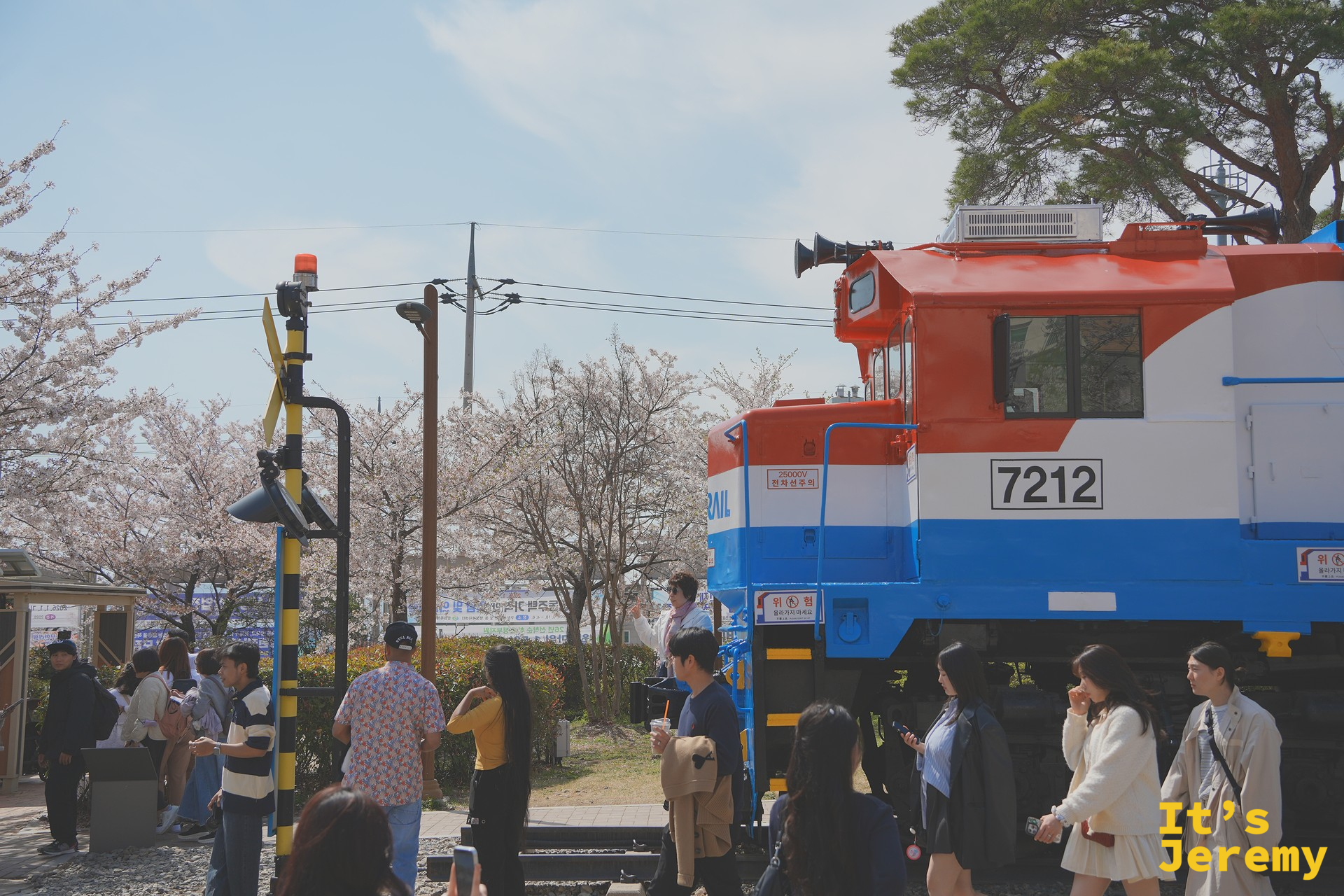 KORAIL 7212 號機車頭的側面近景,和拍照的旅人形成有趣的對照