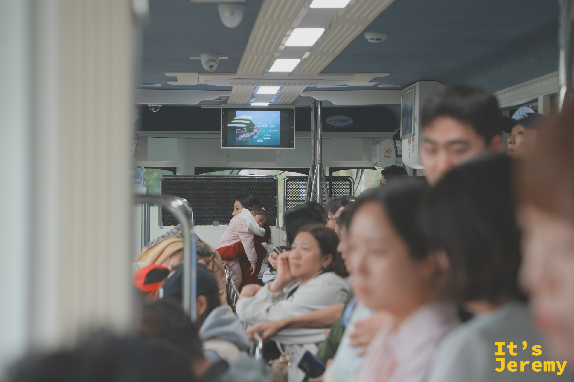 車廂內坐滿乘客，螢幕上顯示著行程約 40 分鐘的提示，氣氛輕鬆熱鬧