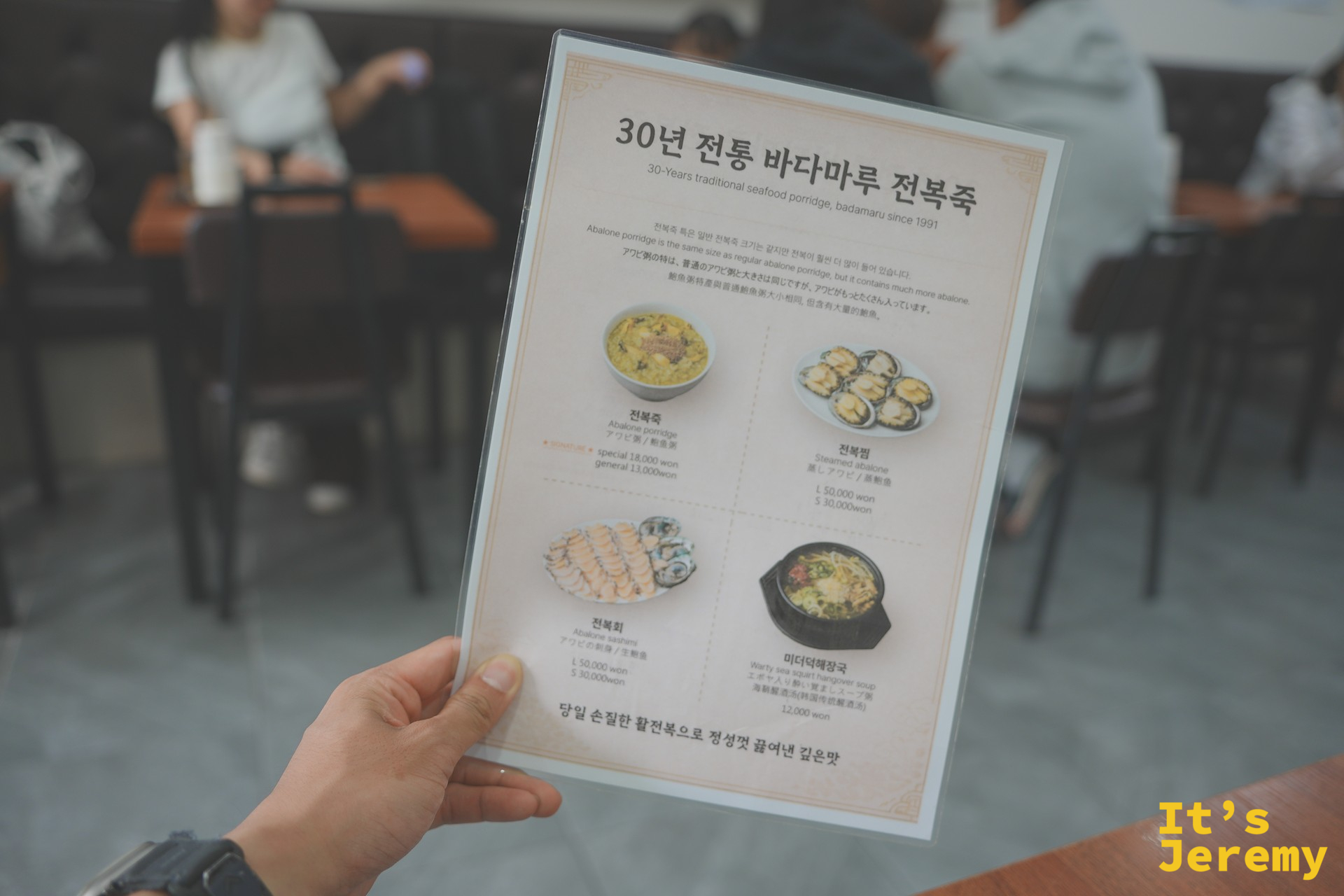手持菜單一覽，四項主要品項一目了然：전복죽、전복찜、전복회、미더덕해장국