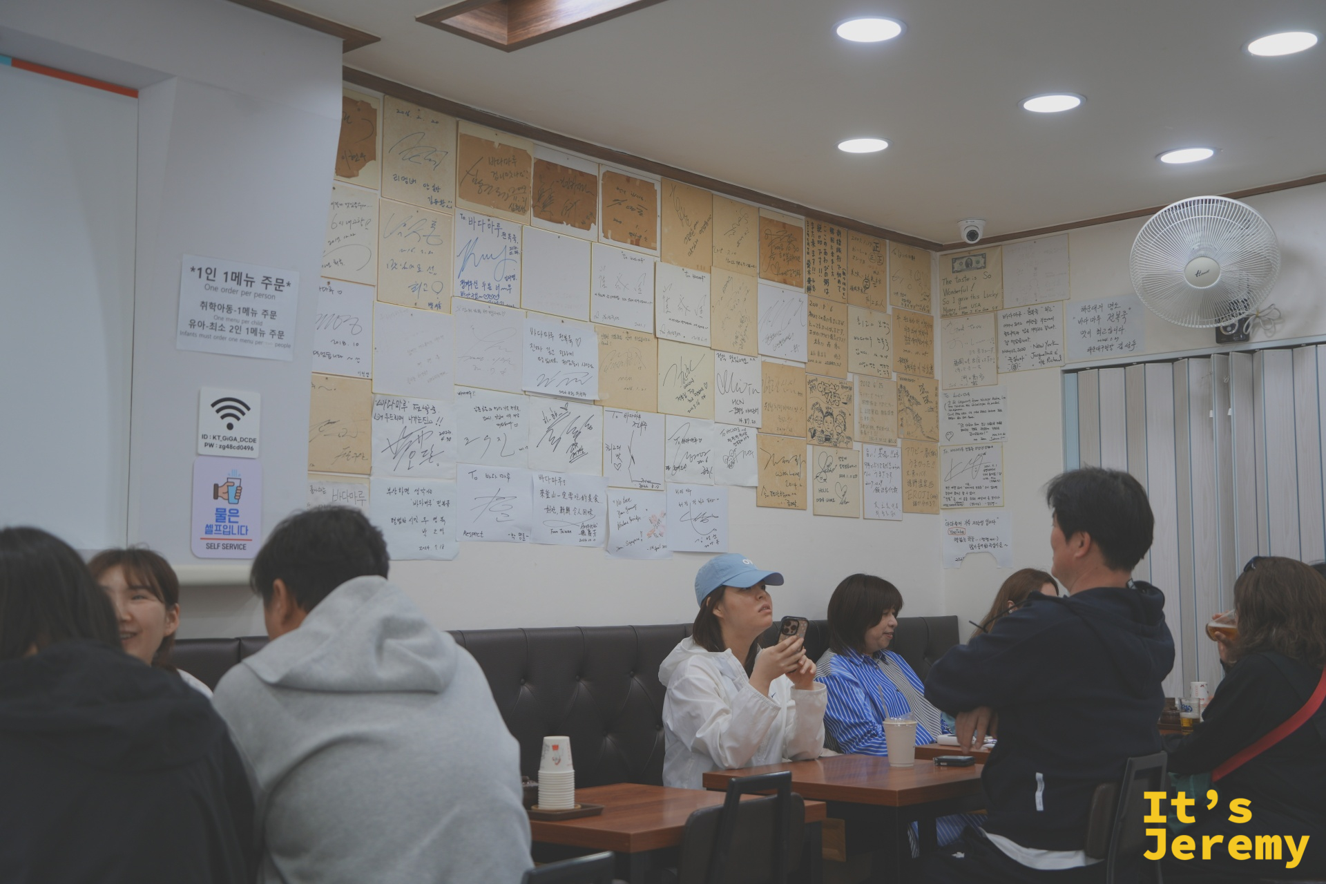 店內一整面牆貼滿各地旅人的手寫留言，從釜山在地客到台灣、新加坡來的遠道旅人都留下了字跡