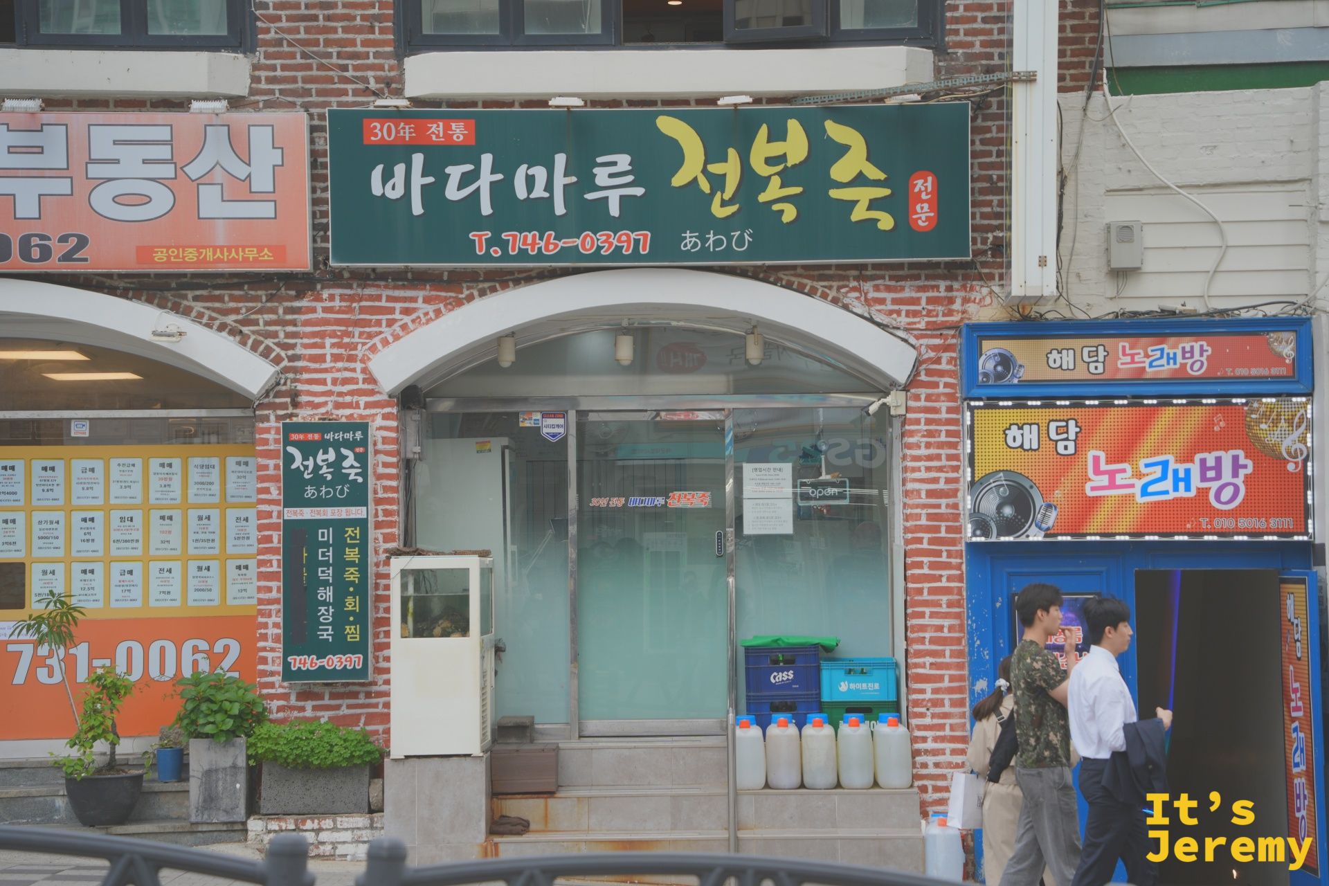 30년 전통 바다마루 전복죽，紅磚外牆配上深綠色招牌，是這條街最有底氣的一塊牌子