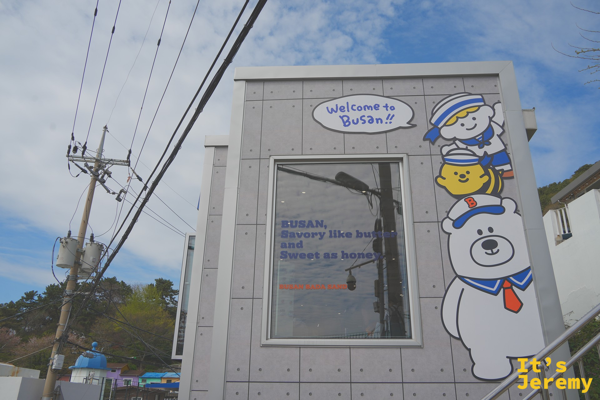 Busan Bada Sand 店外，BOOBA 熊吉祥物角色和「Welcome to Busan!!」標語