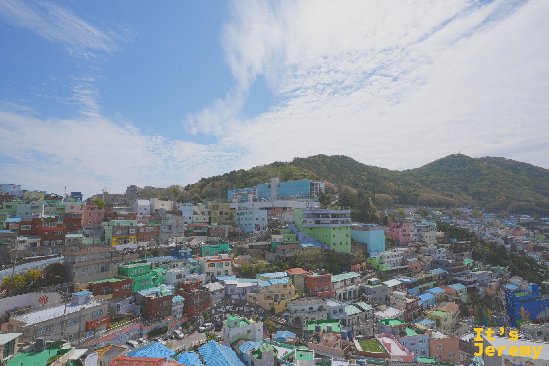 從高處俯瞰甘川洞，彩色屋頂連綿至釜山港邊
