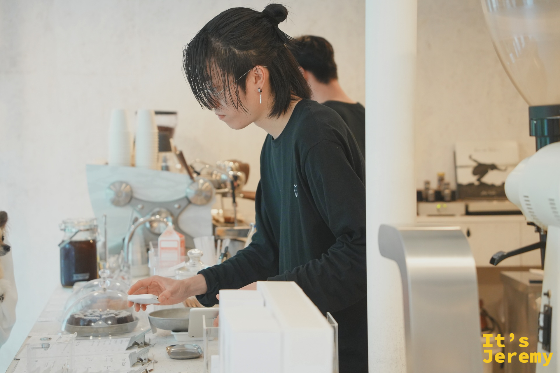 吧台咖啡師專注備製飲品，左側可見復古義式咖啡機